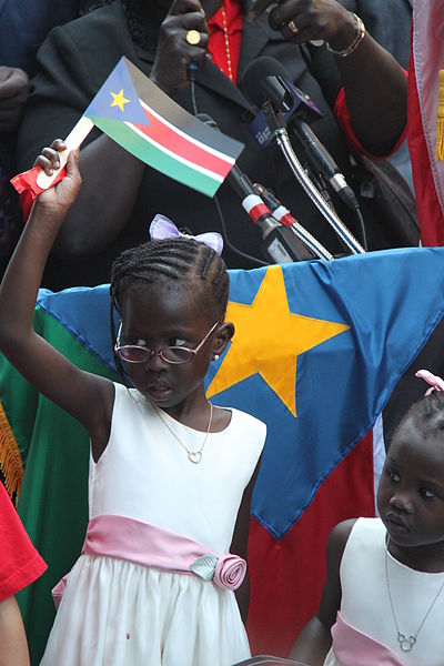 Unabhängigkeitsfeiern in Südsudan, Mädchen schwenkt die Südsudanesische Flagge (c) USAID, Elitre